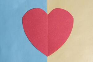 Valentines day concept. The red paper heart on a blue and yellow background. photo