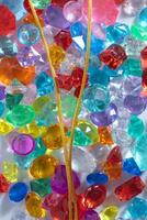 A gold chain over various colorful decorative gems. photo