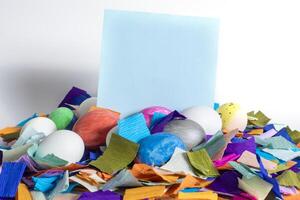 A pile of colorful confetti and an easter egg with a blank card photo