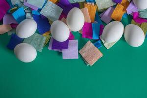 Happy Easter. White eggs with colored crepe paper on green background photo