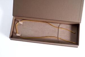 A brown box with yellow cord and a pair of sunglasses inside photo
