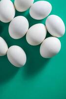 white eggs on a vibrant green background with copy space photo