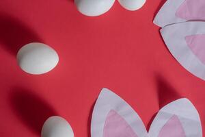 A red background with white eggs and paper cut out ears photo