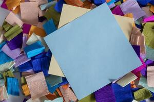 A piece of paper with a piece of paper on top of a pile of colorful paper photo