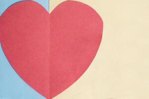 Valentine's Day concept. Red paper heart on a blue and yellow background. photo