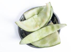 Close-up of empty melon skin pieces in a bowl on a white background, Top view photo