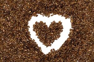 Flax seeds are poured in the shape of a heart. Creative composition for Valentine's Day. Top view. photo