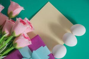 Pink roses and easter eggs on a green background photo