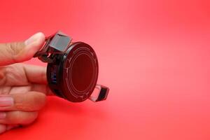 Hand Gripping a Clipped Phone Cooler, Red Background photo