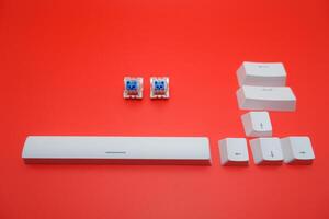 Blue Mechanical Keyboard Switch with Keycaps Isolated on Red Background photo