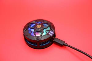Phone Cooling Fan with Attached Cable on Red Background photo