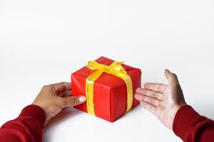 A man's hand wearing a red sweater holds and shows a red gift box photo