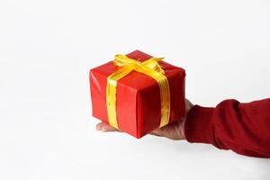 A Festive Red Gift Box Held by a Hand in a Red Sweater photo