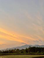 Serene Sunset Landscape with Mountains and Trees photo