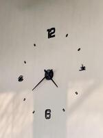 Minimalist Wall Clock with Black Numbers on White Wall photo