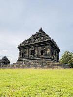 Ancient Stone Temple with Intricate Carvings and green grass. Candi Ijo Temple Yogyakarta photo