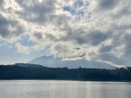Serene Lake with Mountain and Clouds. Lemongan Mountain Lumajang, Indonesia photo