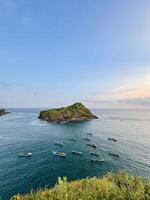 Island and Boats in Tranquil Ocean View. Payangan Beach Jember, Indonesia photo
