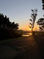 Serene sunrise Silhouette with Road and Water Reflection. Bali photo