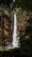 Majestic Waterfall Surrounded by Lush Greenery. Kapas Biru Waterfall Lumajang photo