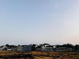 Serene Residential Landscape with Silhouetted Mount Argopuro and Rustic Charm photo