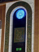 Intricate Arabic Calligraphy with Decorative Clock photo