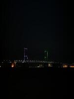 Suramadu Bridge Over Madura Strait with Calm Ocean and Blue Sky. Longest Cable-Stayed Bridge in Indonesia, Coastal View, Urban Skyline, Maritime Landmark, Travel Destination, Tourism, Architecture. photo