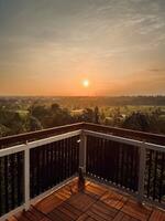 Sunset View from a Wooden Balcony Overlooking Green Fields photo