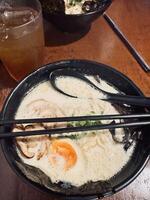 Creamy Ramen with Beef and Egg on Wooden Table photo