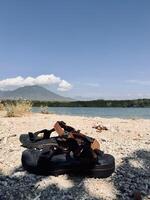 Sandals on Rocky Lakeshore with Mountain View. Baluran Mountain, Sijile Beach photo