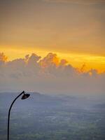 Golden Sunset Over a Misty Valley with a Rustic Street Lamp photo
