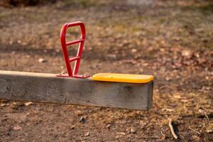 Metal swing on a playground in a park in early spring, side view of the seat photo