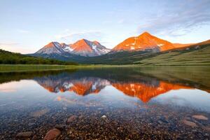 awakening of majestic mountain range, an ethereal sunrise unveils shimmering vast expanse of natures majesty photo