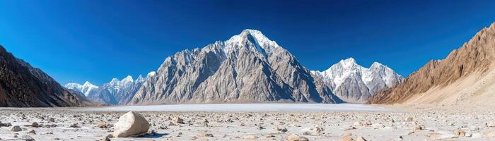 majestic panorama, jagged teeth of azure sky overlooking rugged peaks of snow-covered mountain expanses photo