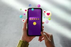 Customer Experiences Concept. Happy Client Using Smartphone to Giving Five Stars Review Rating via Online Satisfaction Surveys. Positive Feedback on Mobile Phone photo