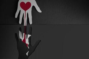 Donation, Helping, Support Concepts. Paper Cut as Hands Shape hanging on the wall. look like the top one Connecting the one below with a Red Heart photo