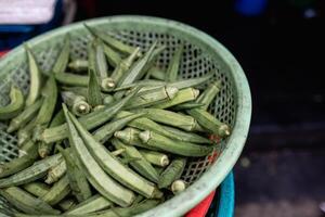 Lots of fresh and green and organic Okra , Lady Finger in basket at a local Indian vegetable market. photo