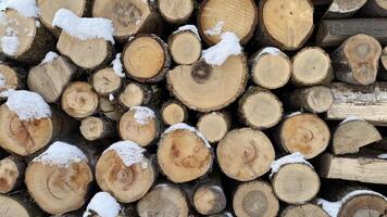 Snow-Dusted Stacked Firewood Logs in a Winter Outdoor Setting. Stacked wooden logs with a light dusting of snow, portraying a cozy winter environment and a rustic, natural atmosphere. photo