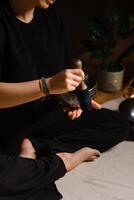 Practitioner uses singing bowls for meditation in a serene studio environment during a mindful evening session photo