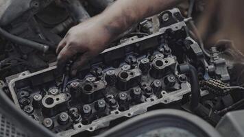 Close-up of a mechanic hands fixing an exposed engine block in a vehicle, showcasing detailed automotive repair work. video