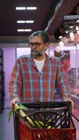 Senior man pushing shopping cart in supermarket aisle video