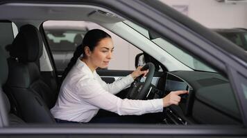 Woman testing car touchscreen and controls before purchase video