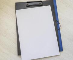 plastic folder on the desk with paper clip holder on the top. A4 size paper mock up. Stationary photo