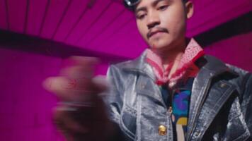 Young Man Examining Object in Colorful Setting video