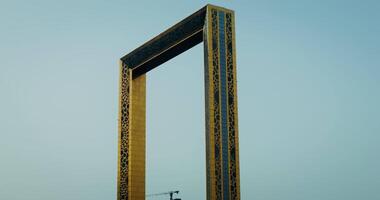Dubai frame in bright sunlight reflected in the windows, bottom view against a clear blue sky video