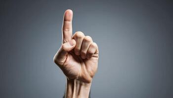 Close-up of an Aged Hand Pointing Up Against Gray Background photo