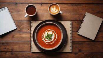 Tomato Soup with Coffee and Notebooks on Wooden Table photo