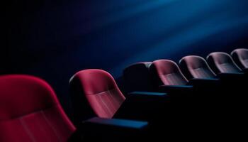 Empty Red Velvet Seats in a Dark Movie Theater with Blue Lighting photo