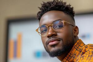 Smartly dressed man with glasses poses confidently in a modern workspace during daylight photo