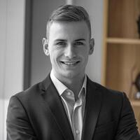 A man in a suit and tie smiling for the camera photo